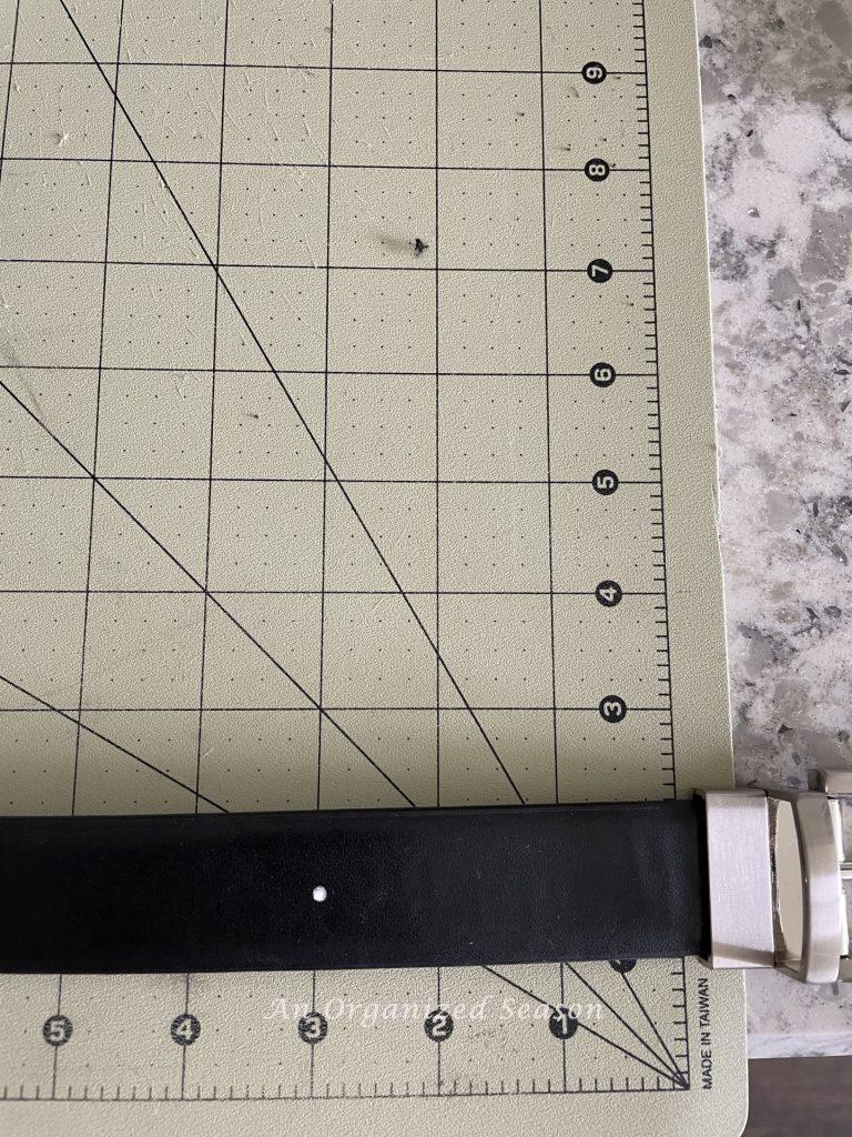 White dot on belt at the three inch mark. 