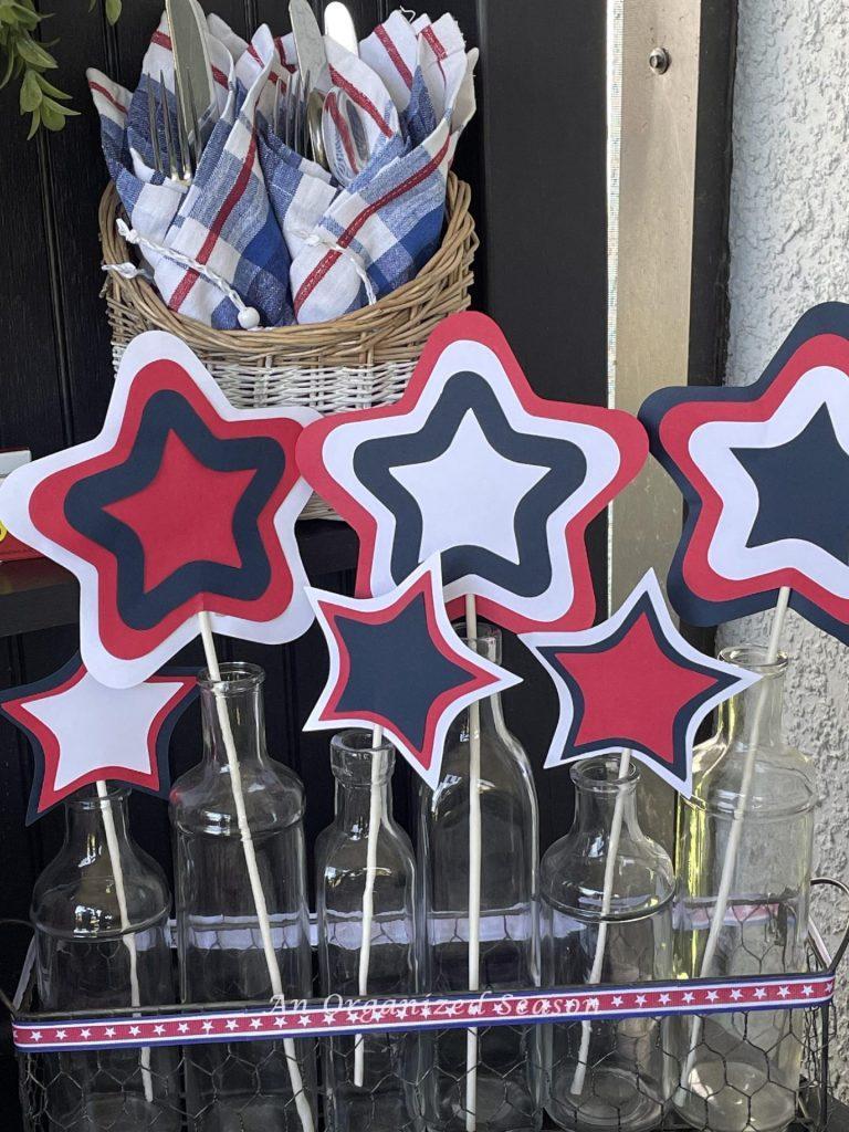 Red, white, and blue paper stars on candy sticks displayed in glass vases. 