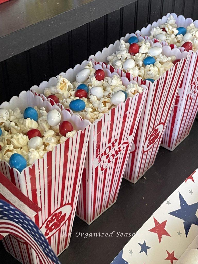 Popcorn boxes filled with popcorn and red, white, and blue peanut M&Ms. 