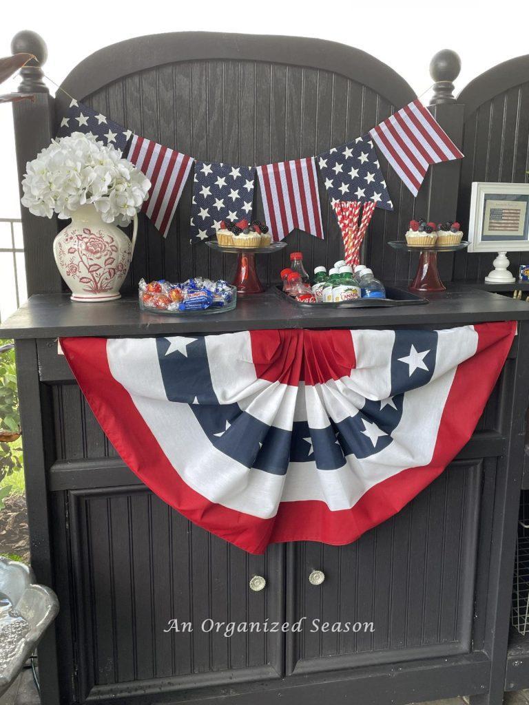 Potting bench holding drinks and food for a 4th of July party. 