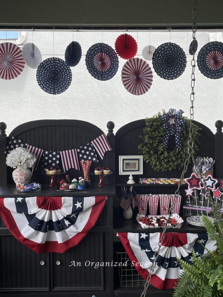 Patriotic idea number five is to hang red, white, and blue paper fans above a potting bench. 