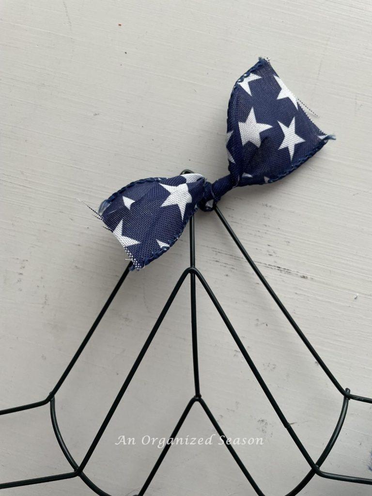 Tie blue and white ribbon onto a start wreath form  to make a DIY 4th of July wreath. 