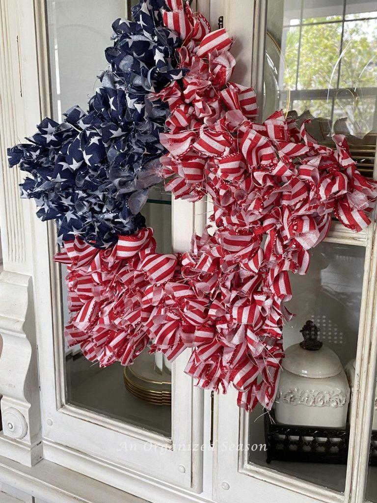 a DIY 4th of July wreath hanging on a china cabinet. 