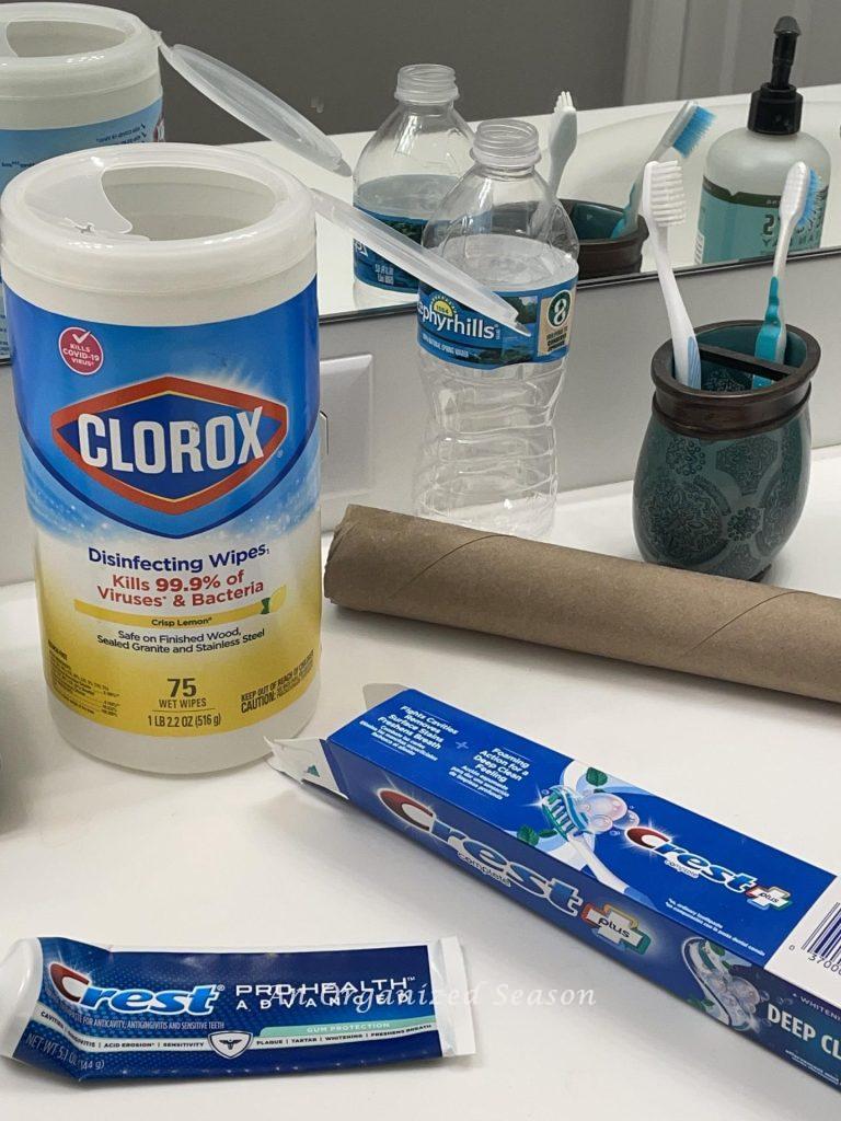 A bathroom counter cluttered with empty containers.