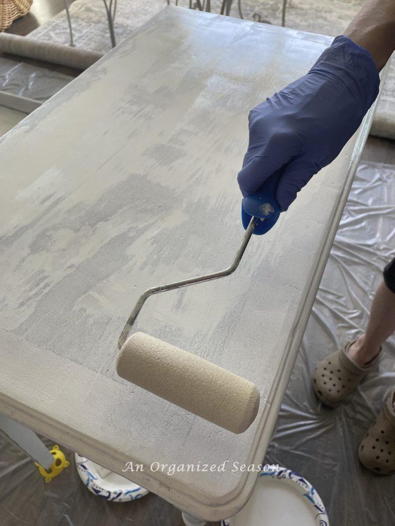 Apply primer to furniture with a sponge roller before you paint it. 