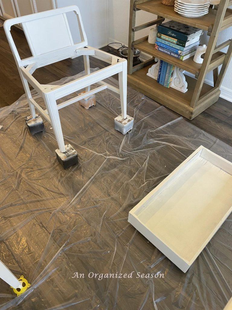 Apply two coats of white paint to get good coverage on furniture. 