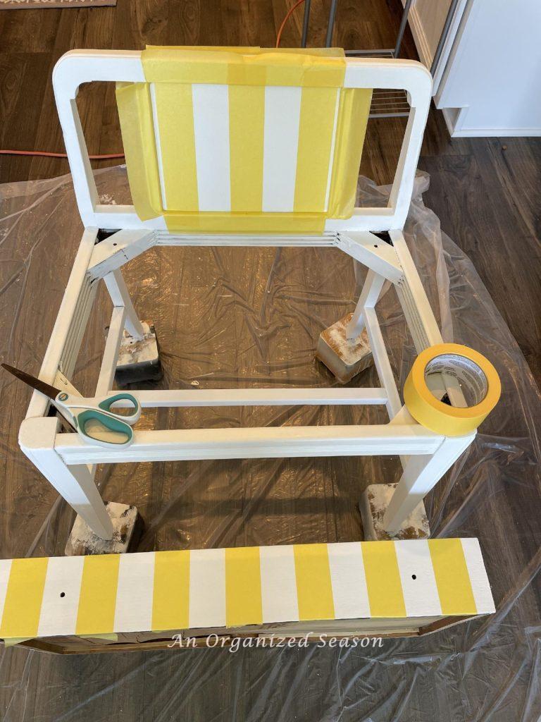 Paint stripes on furniture by using yellow Frog Tape. 