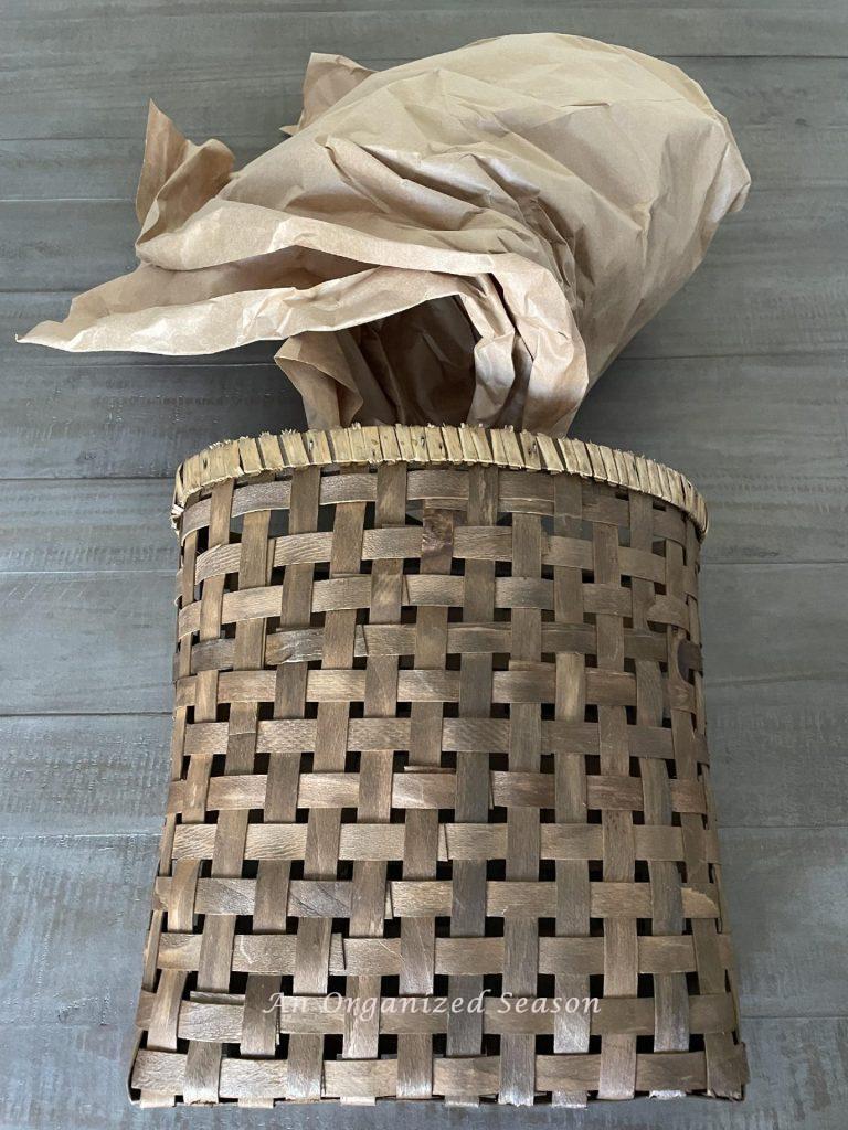 Step one to make a lavender wreath is to stuff brown packing paper into a basket. 