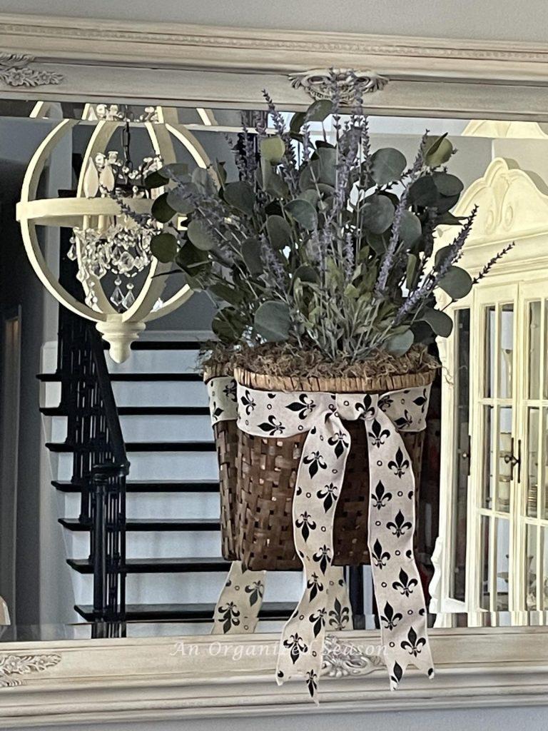 A basket of lavender and eucalyptus hanging on a mirror.