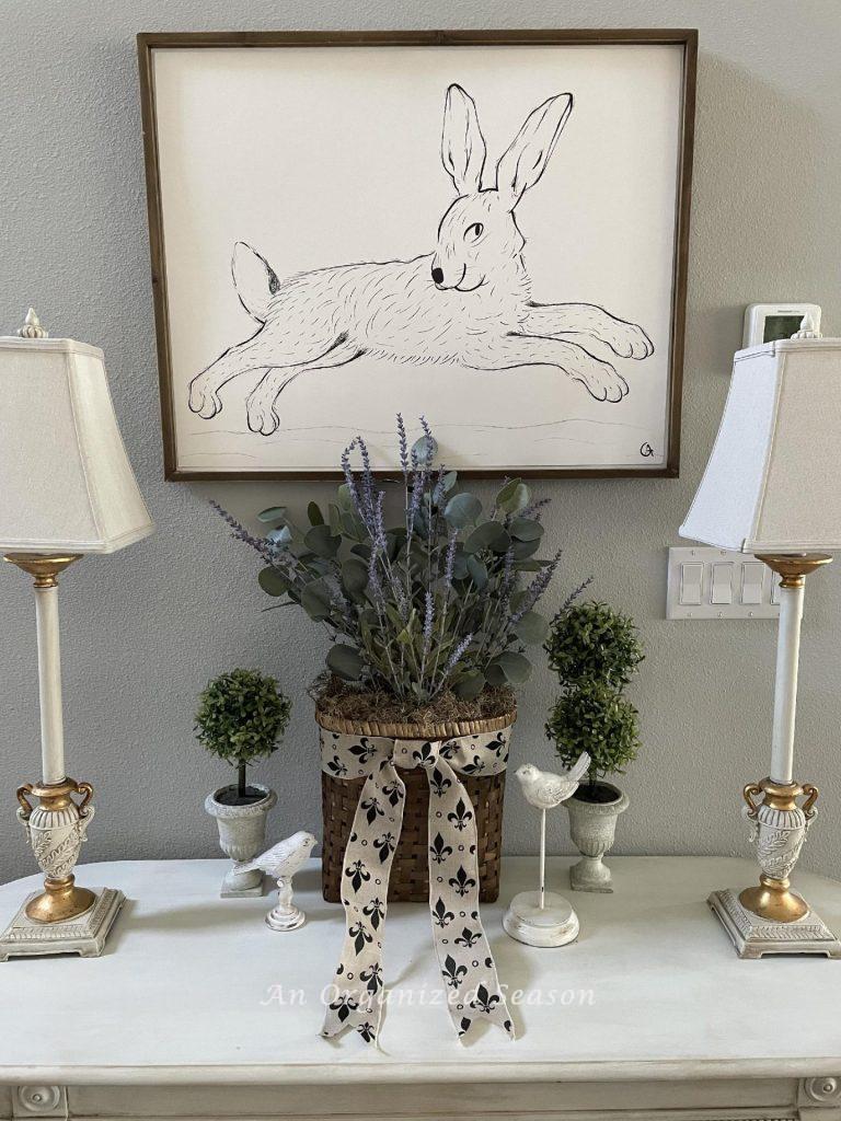 A basket of lavender and eucalyptus sitting on a foyer table.