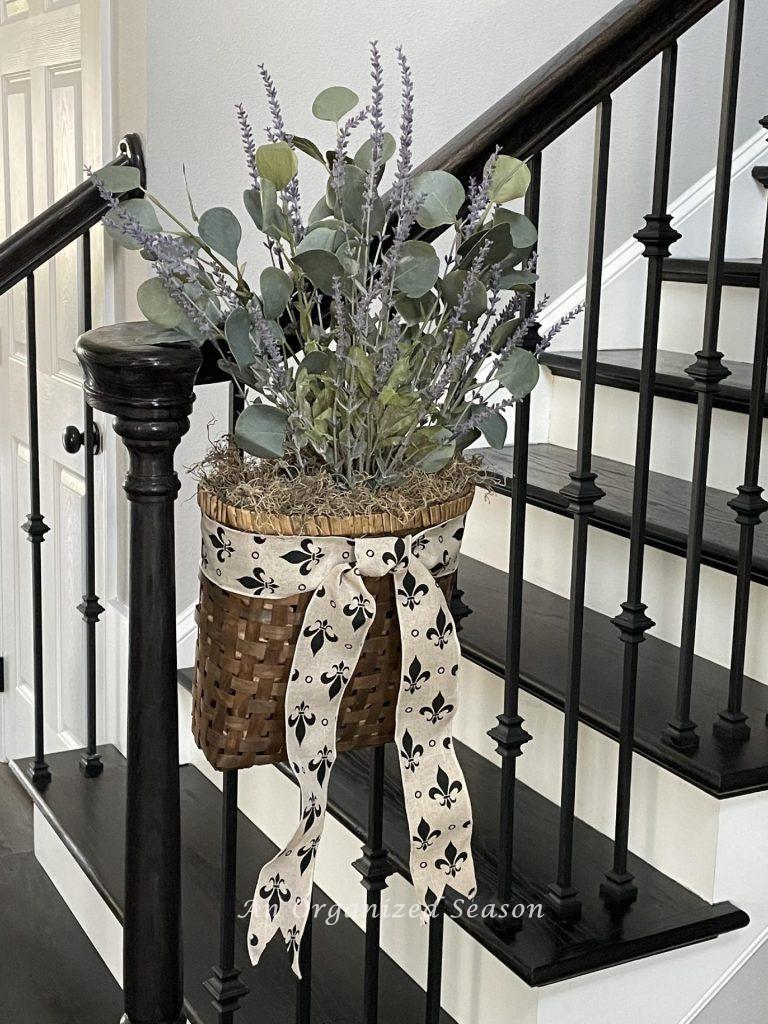 A basket of lavender and eucalyptus hanging on a staircase.