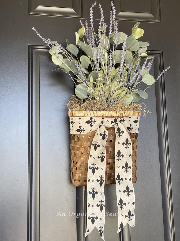 A basket of lavender and eucalyptus hanging on a front door. 