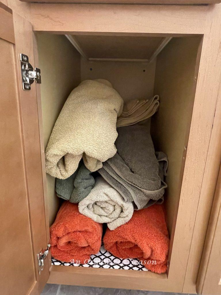 Messy towels in a bathroom cabinet.