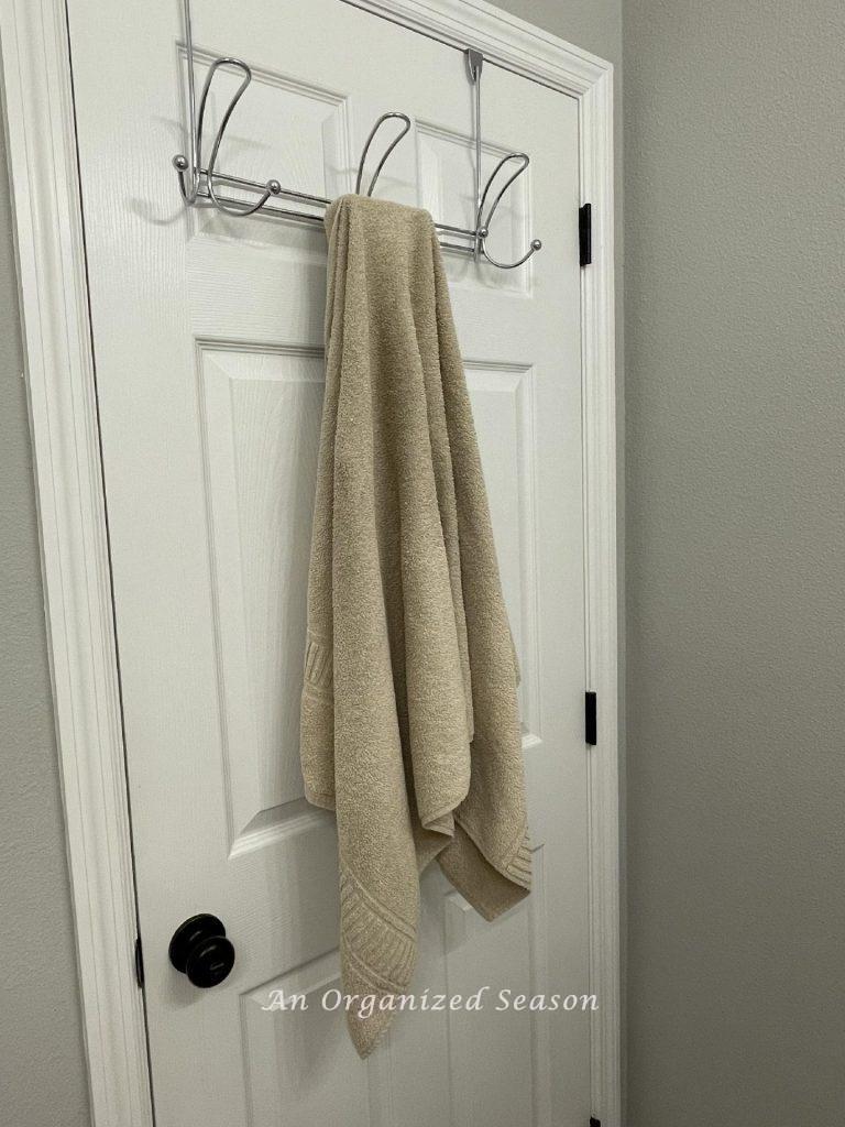 A towel rack hanging on the back of a bathroom door. 