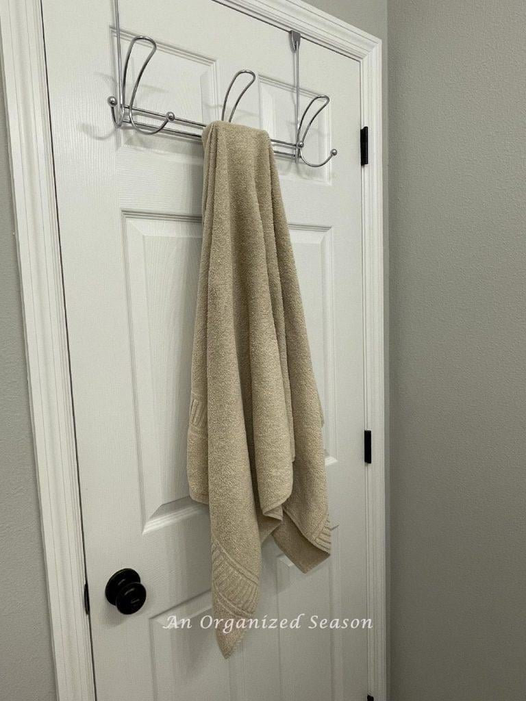 A towel rack hanging on the back of a bathroom door.