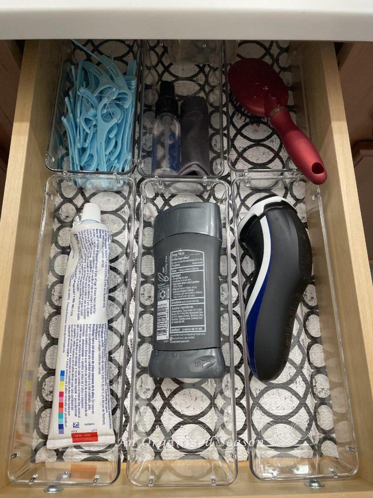 A bathroom drawer organized with clear bins in various sizes.