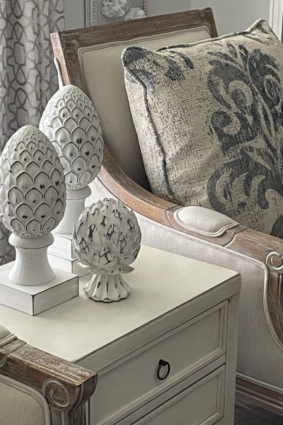 Three white, distressed artichoke sculptures.