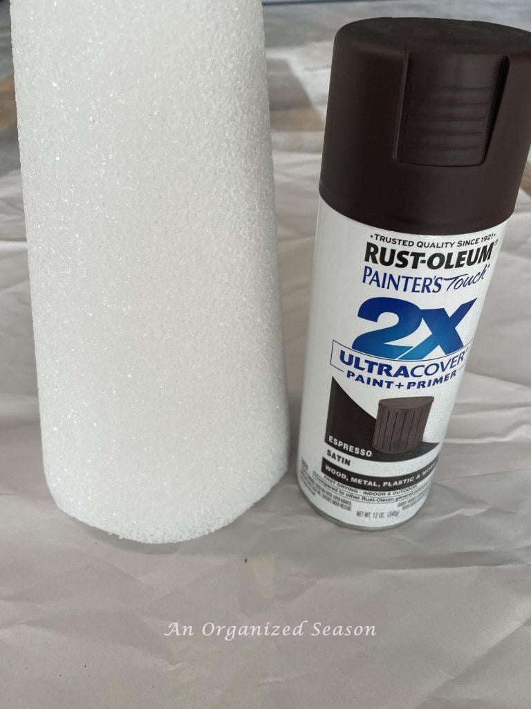 Step two to make a pinecone Christmas tree is to spray paint a styrofoam cone brown.