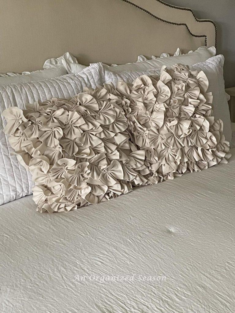 Ruffled pillows on a white bed. 