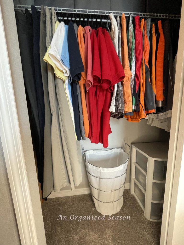An organized closet with clothes arranged in sections. 