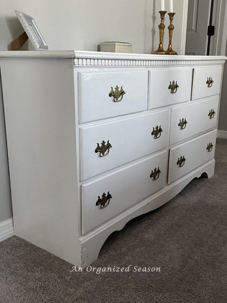 A white dresser with gold handles. 