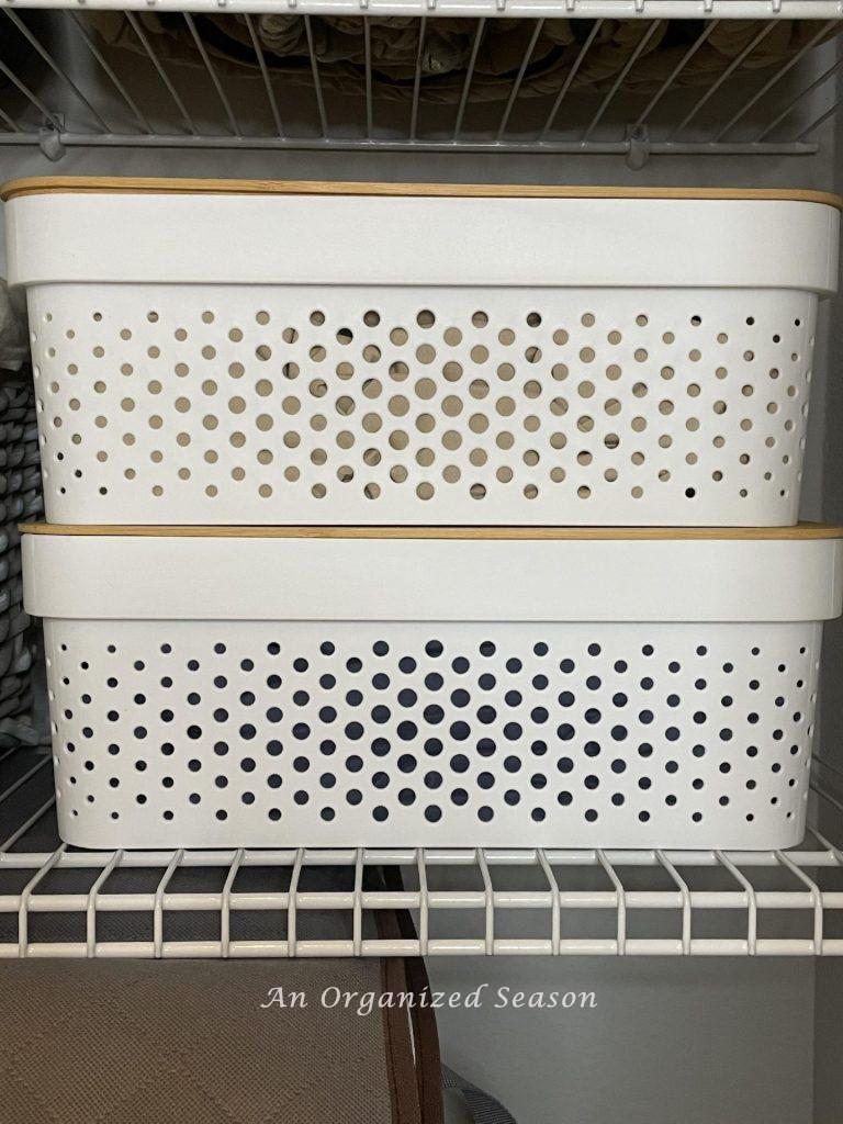 Two white plastic storage bins with bamboo tops. 