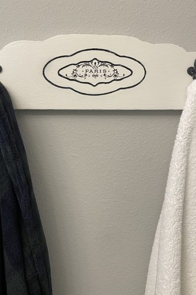 French-inspired towel rack holding a rob and towel.