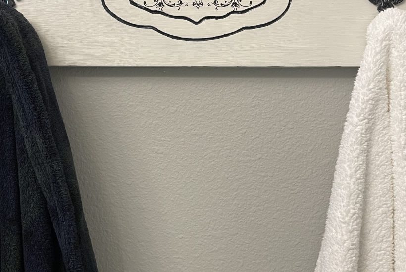 French-inspired towel rack holding a rob and towel.