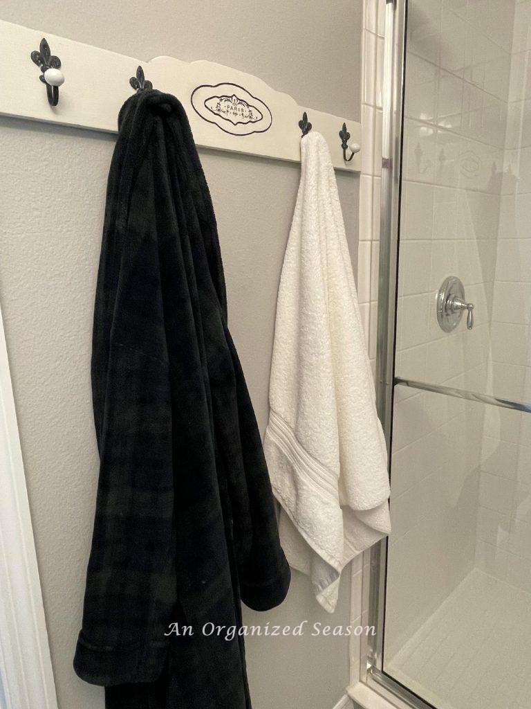 A towel rack holding a towel and robe.