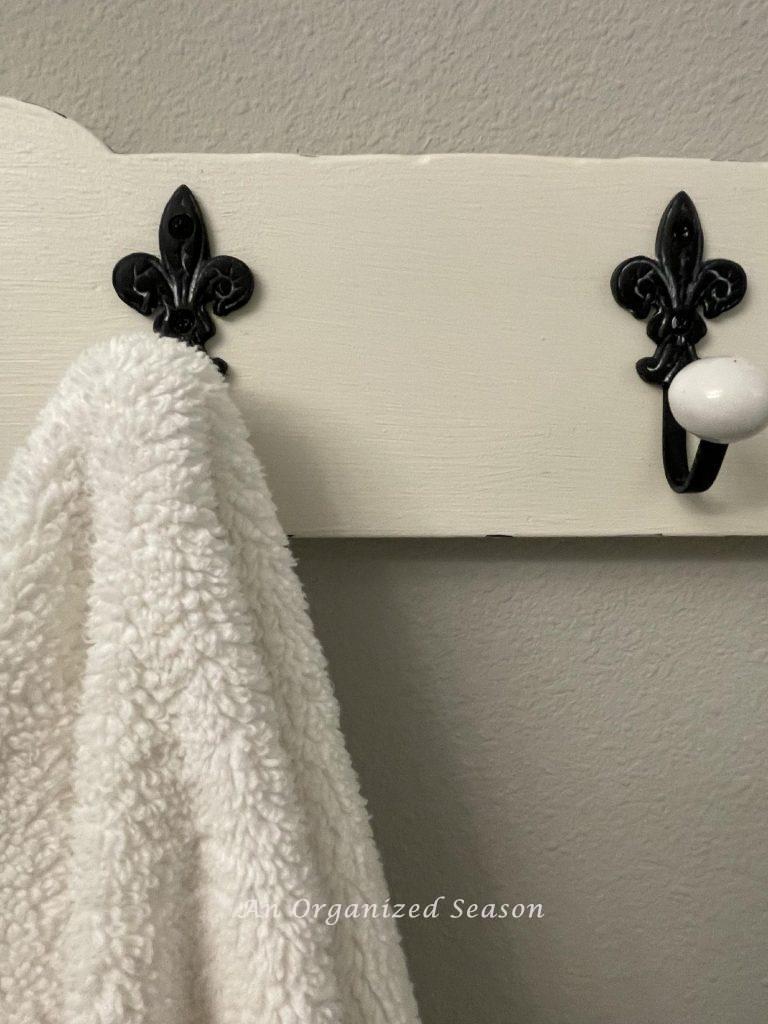 Fleur dis lis towel hooks on a white board. 