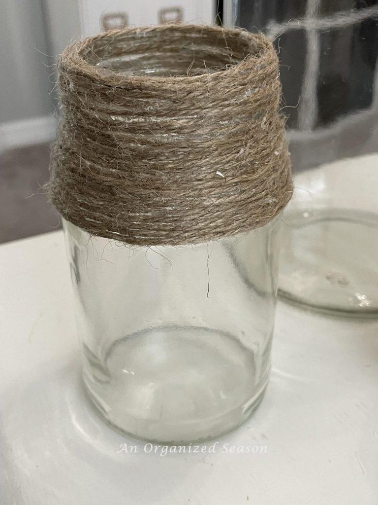 Step five to make a DIY vase is to cover all the writing with twine. 