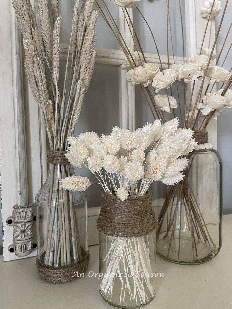 Three vases with dried flowers. 
