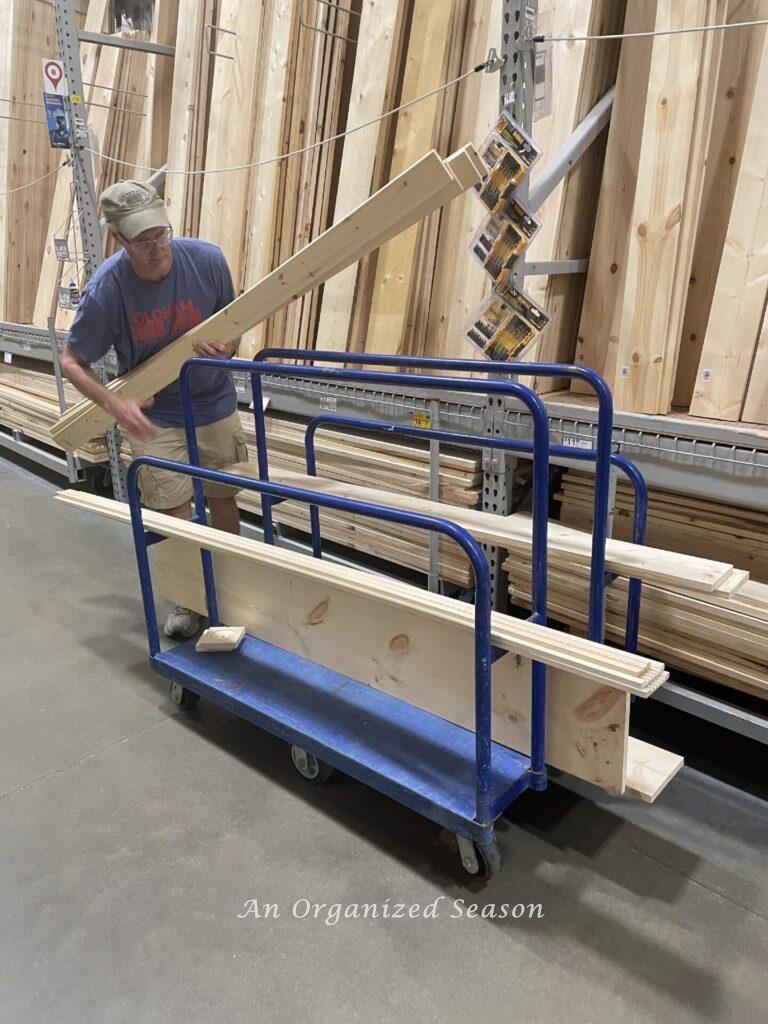 man loading boards on cart at Lowes to make a faux fireplace mantel