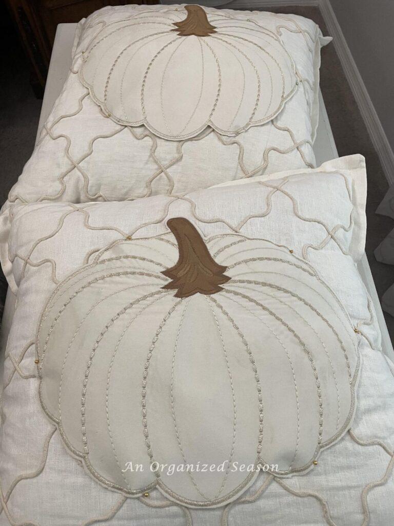 Two pillows with a pumpkin placemat pinned to the front. 