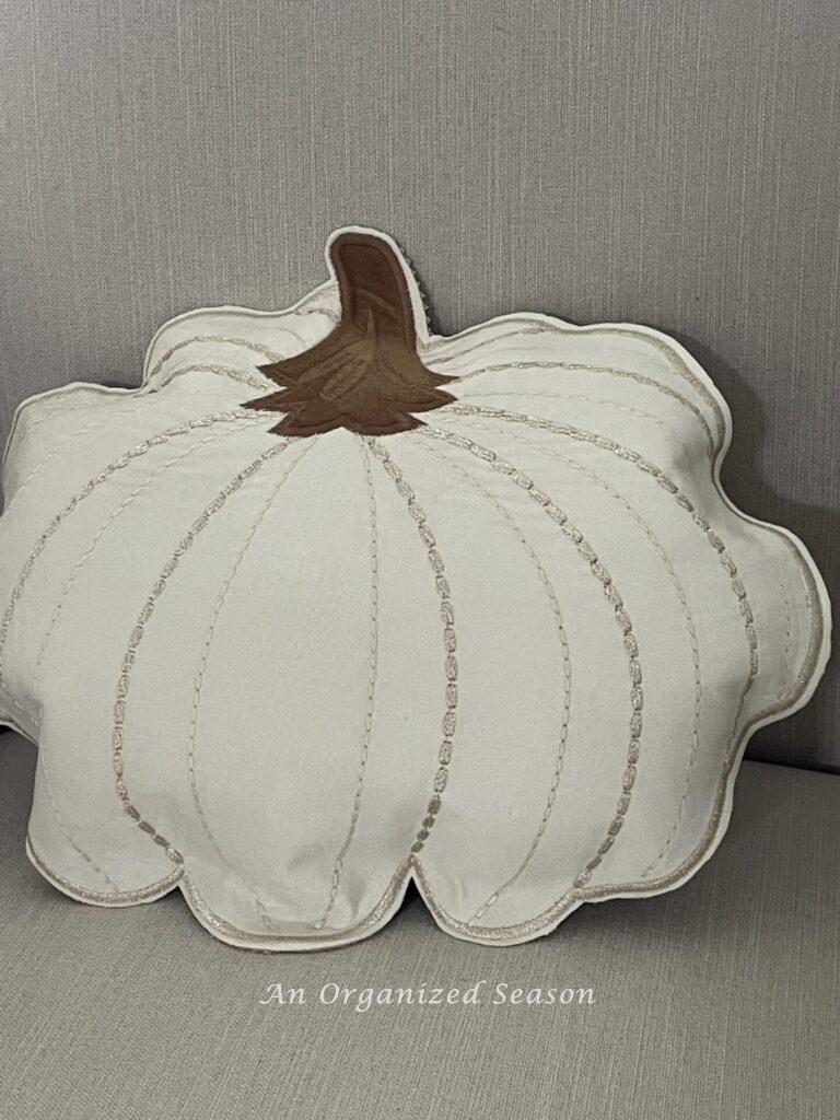 A neutral stuffed pumpkin pillow made from a placemat.
