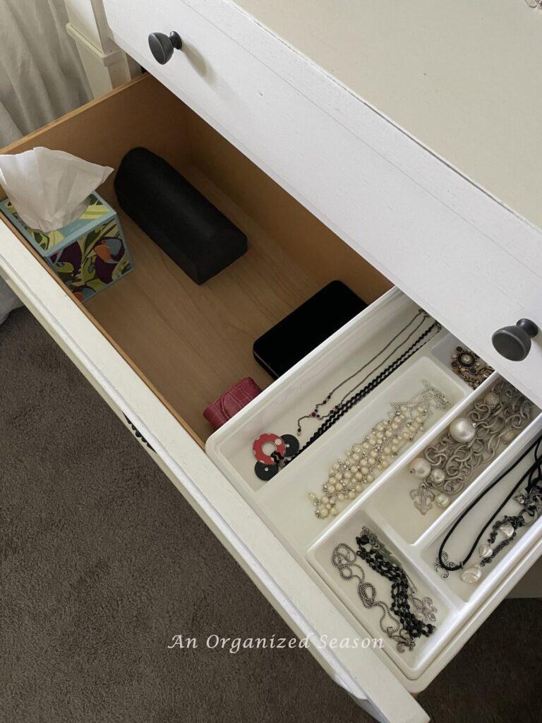 A good nightstand organization idea is to use a jewelry storage bin in a drawer. 