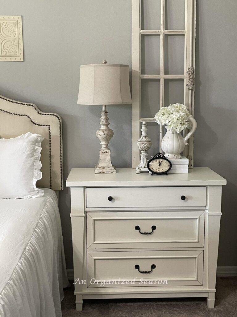 A white organized nightstand in a bedroom. 