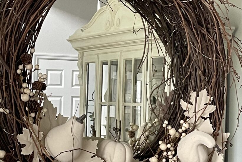 Neutral Fall pumpkin wreath hanging on a mirror.