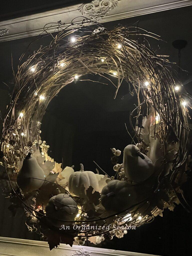 Pumpkin wreath in the dark with fairy lights turned on. 