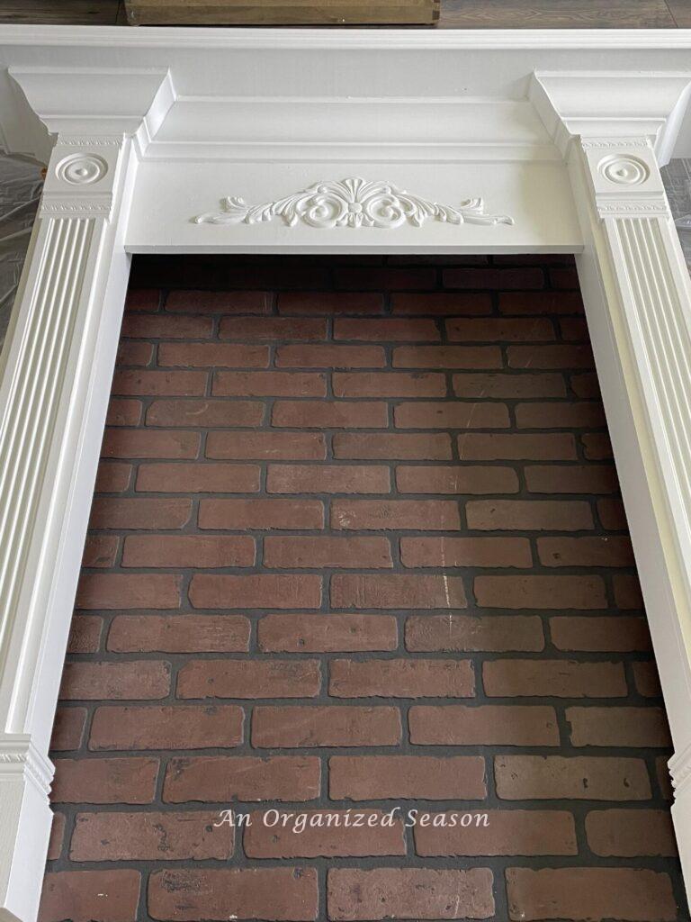 Painted mantel with faux brick sheet underneath