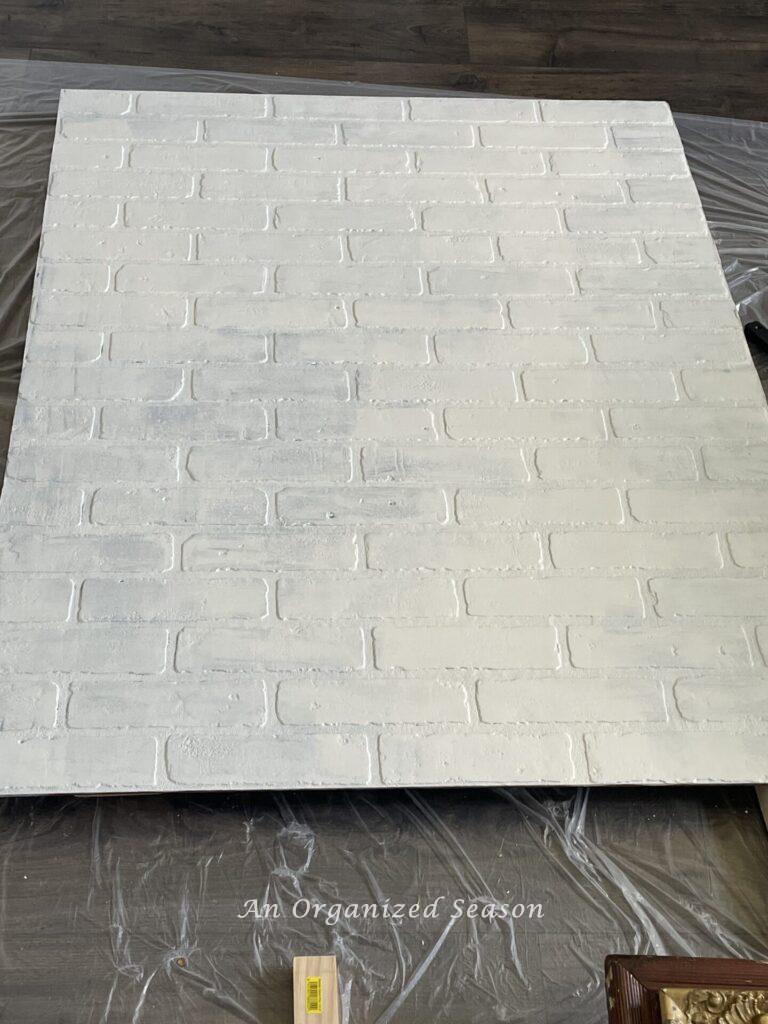 Partially primed and painted faux brick sheet material