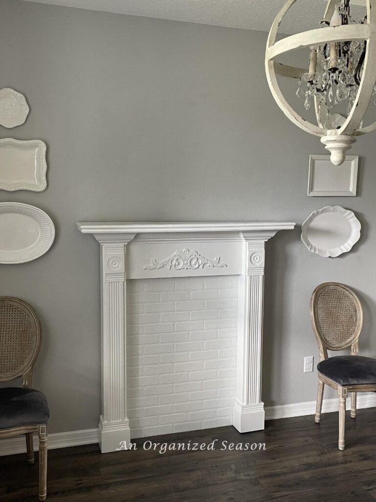 A white faux fireplace mantel in a dining room. 