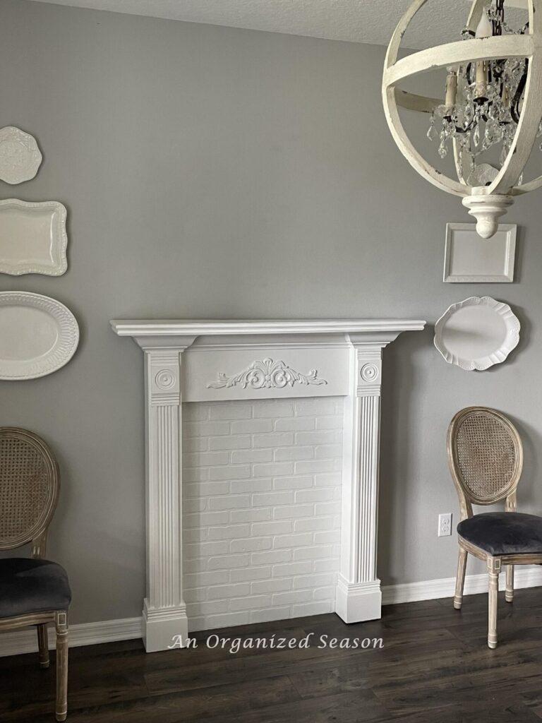 A white faux fireplace mantel in a dining room.