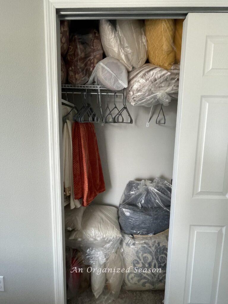 A closet filled with bags of throw pillows. 
