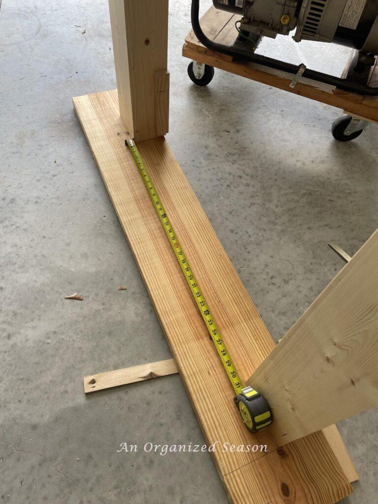 tape measure showing length between columns being test fit on mantel shelf