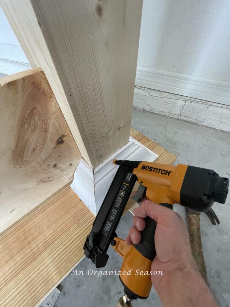 Brad nail gun nailing crown molding to column