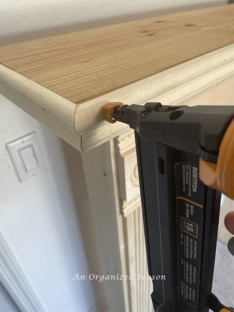 Brad gun nailing chair rail  trim to faux fireplace mantel shelf