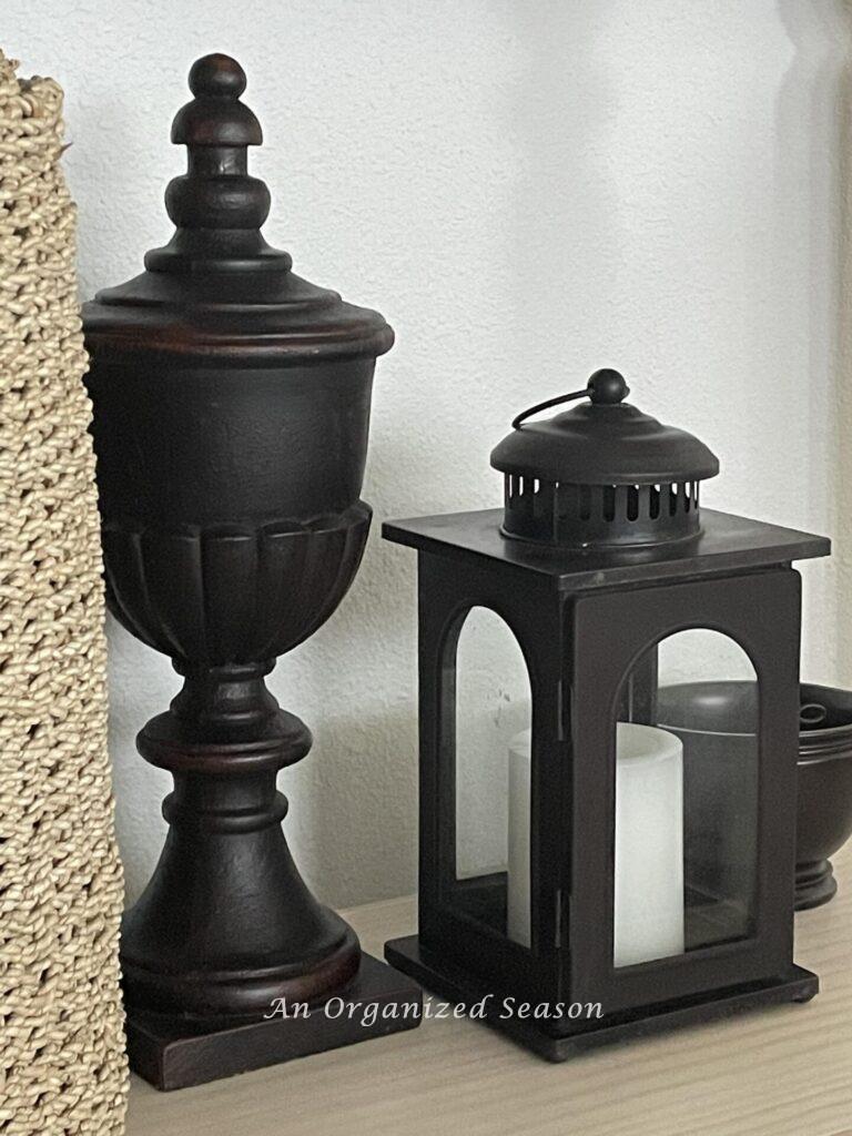 A brown corbel next to a brown lantern and small bowl. 