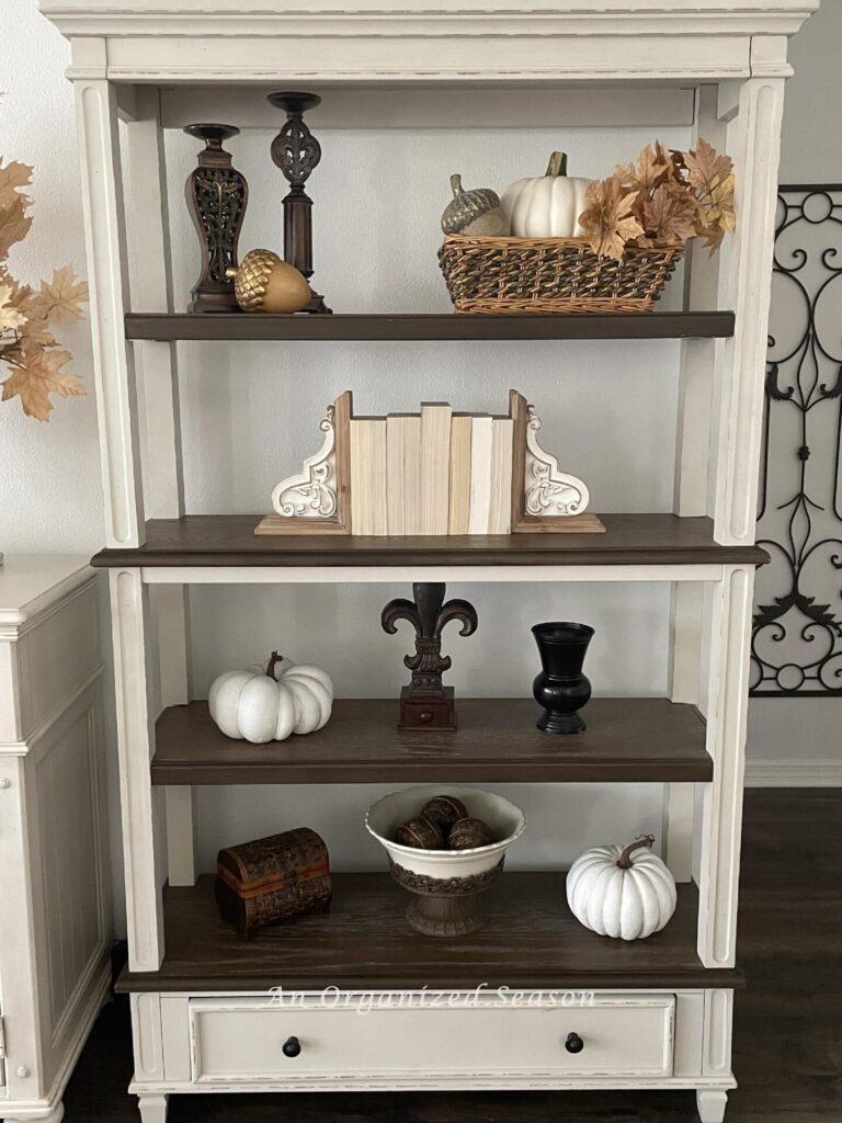 A bookshelf decorated for fall.