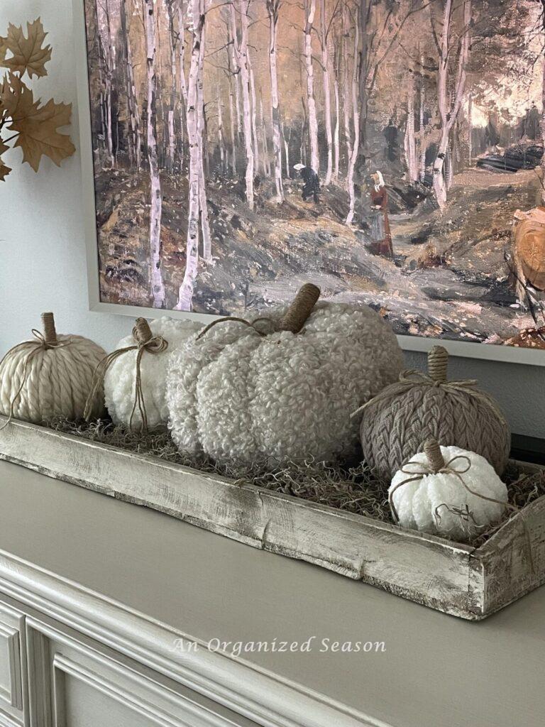 A tray filled with yarn pumpkins. 